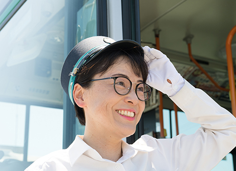 女性社員が敬礼して笑っている写真