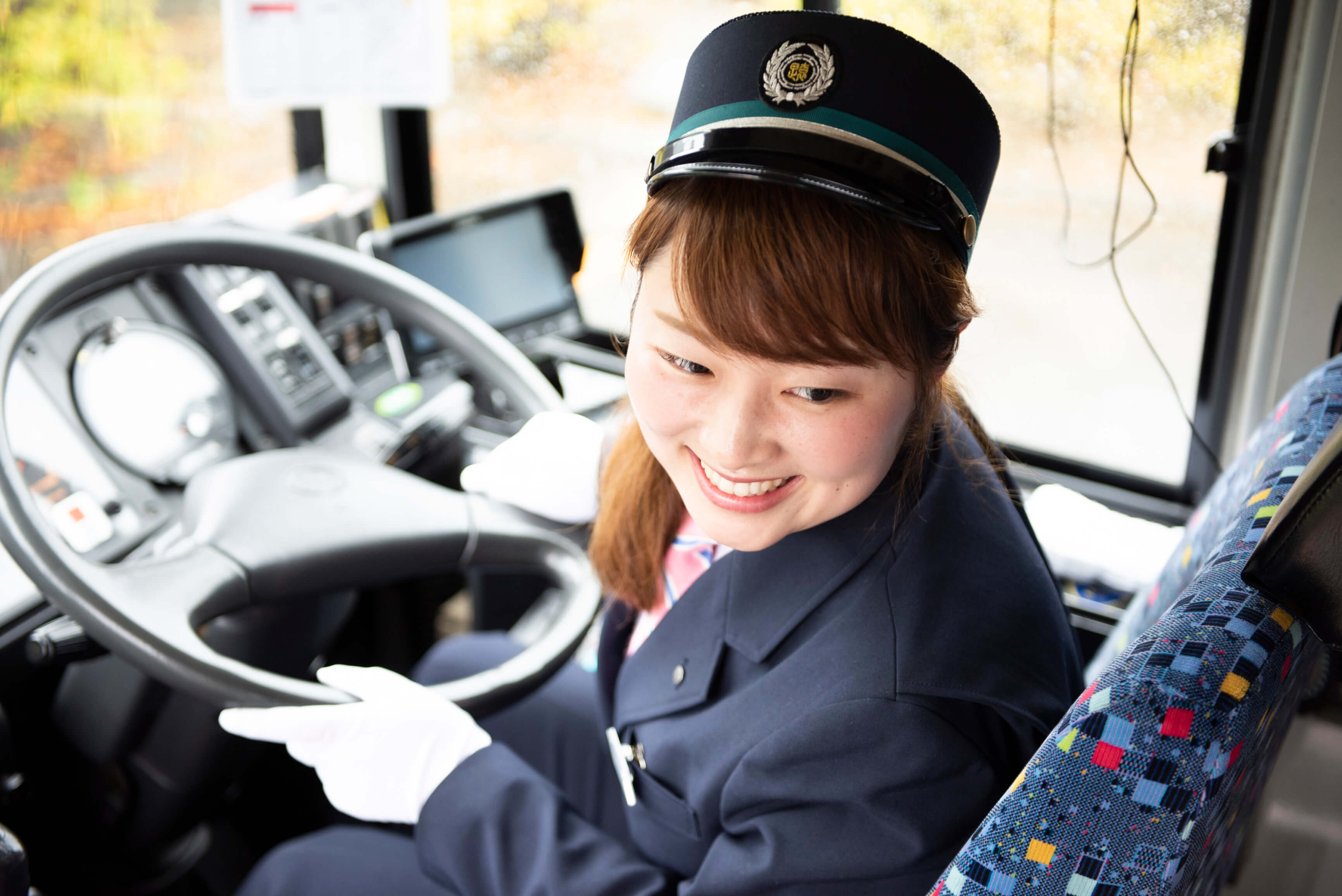女性社員が運転席から後ろを振り返って笑っている写真